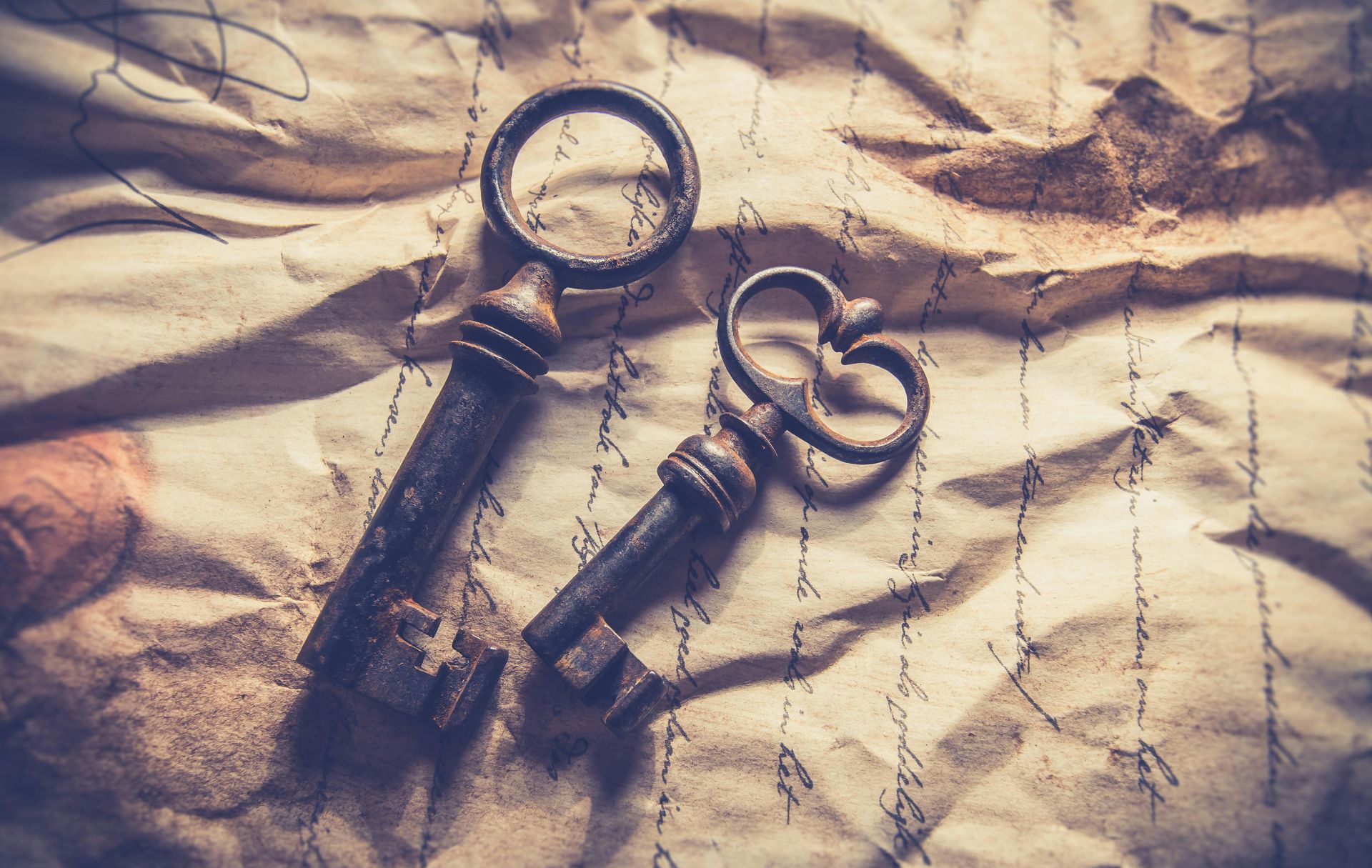 Two keys are laying on top of a piece of paper.