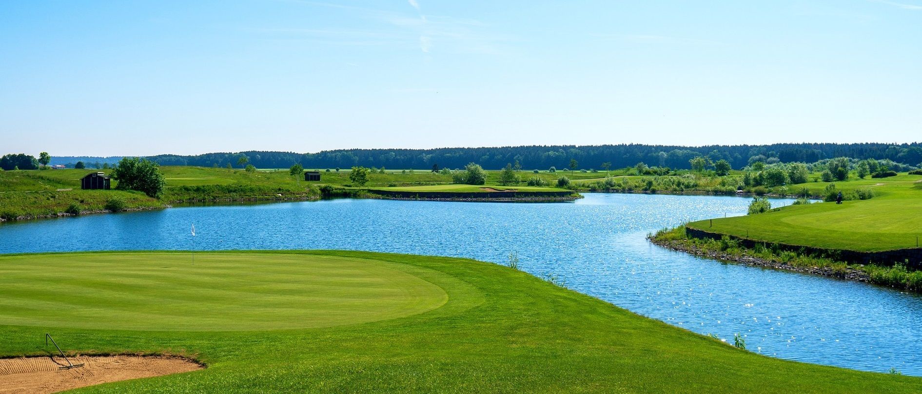 A golf course with a lake in the middle of it.