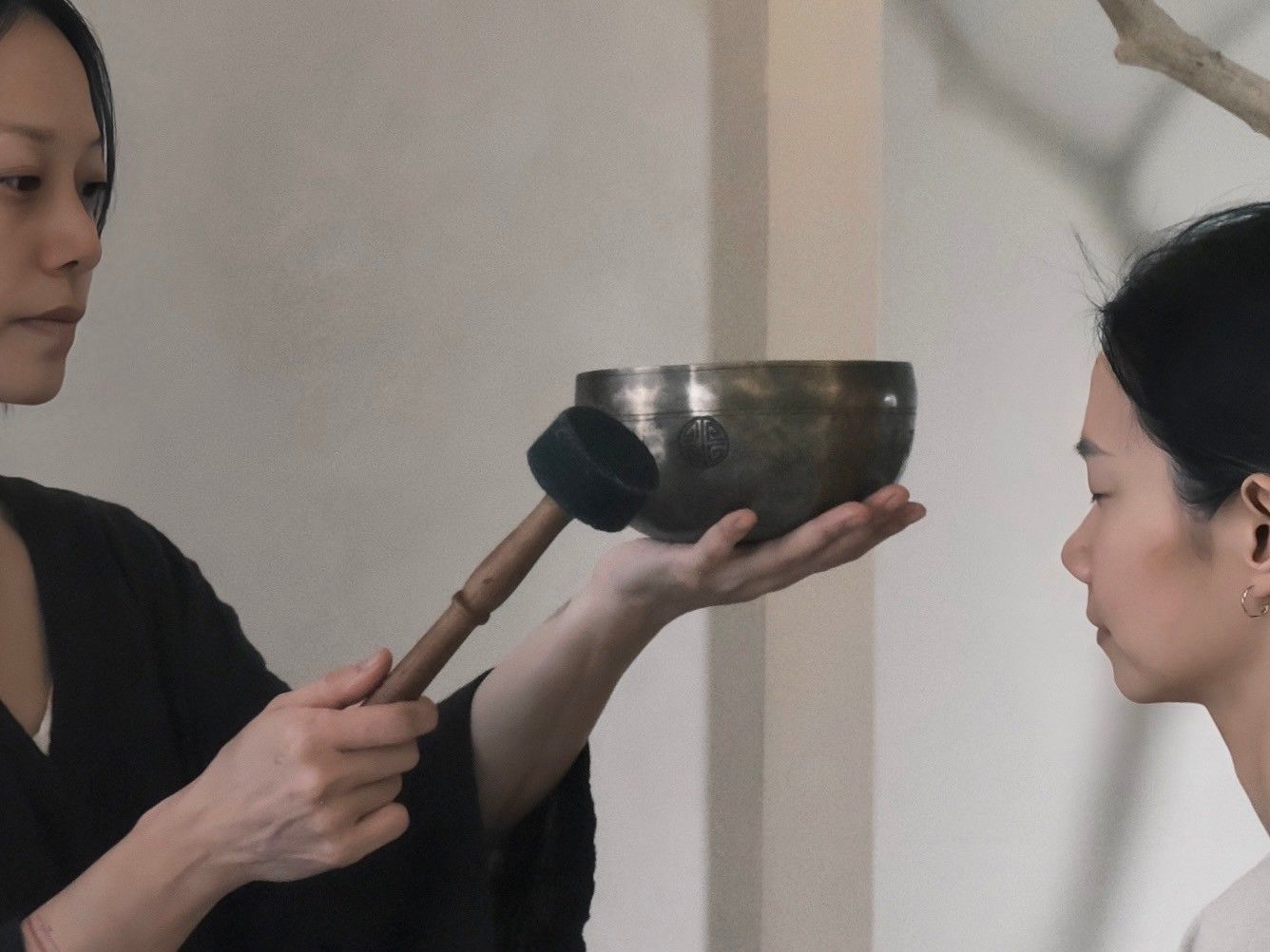 A woman is holding a bowl and a brush in her hands