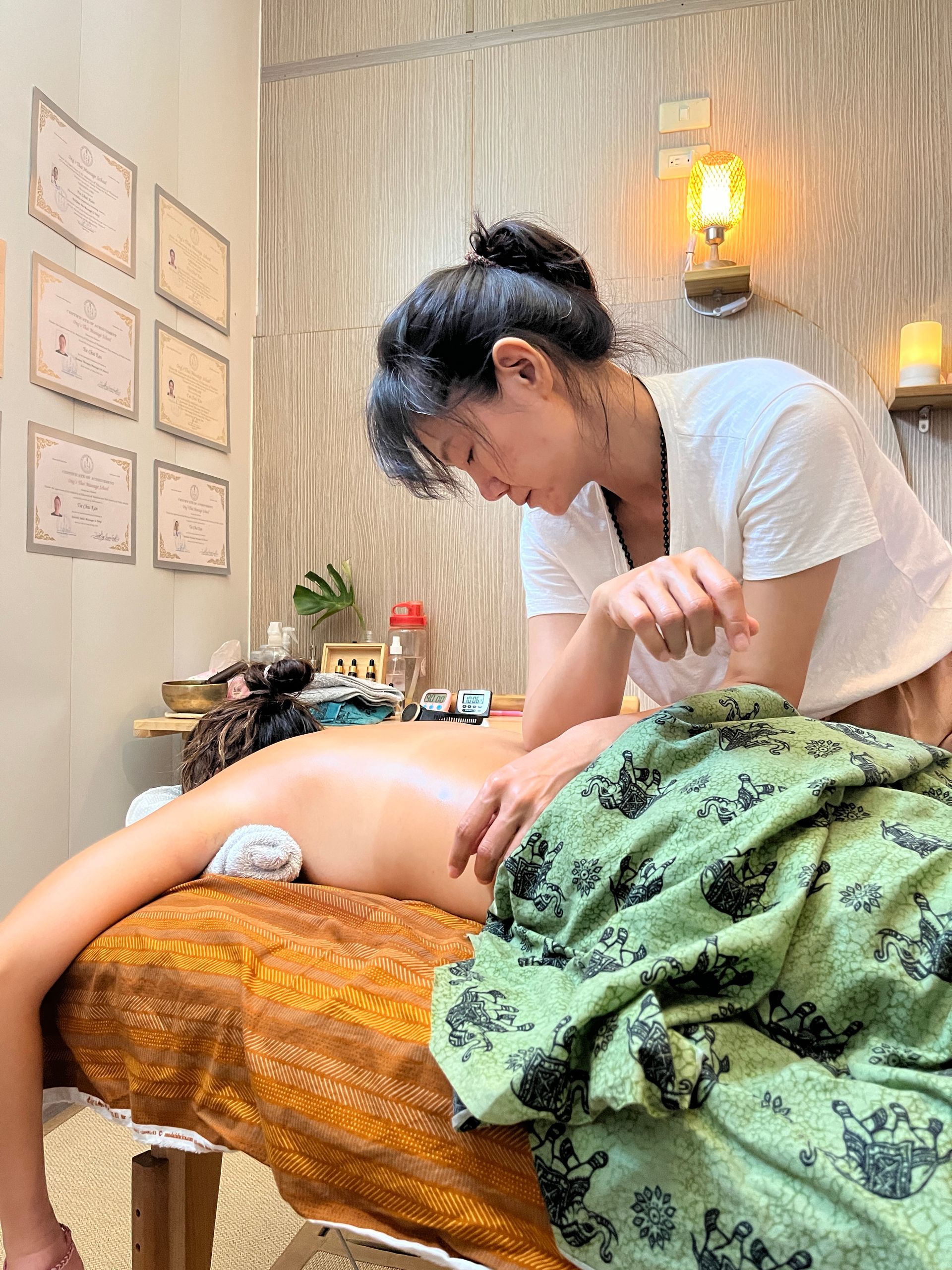 A woman is giving a massage to a child on a massage table.