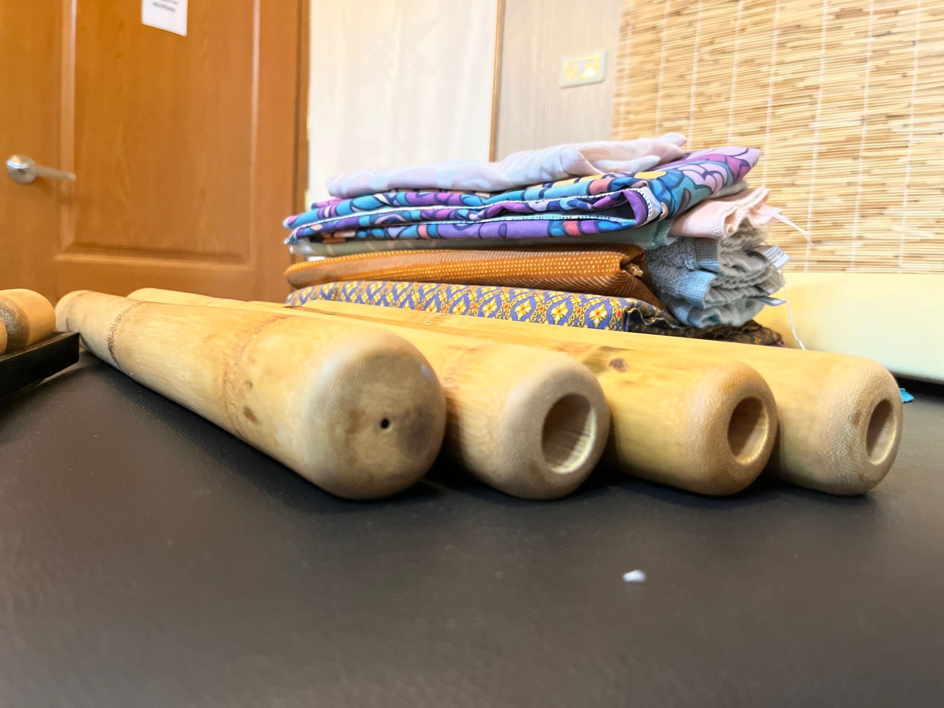 A bunch of wooden sticks are sitting on a table next to a pile of fabric.