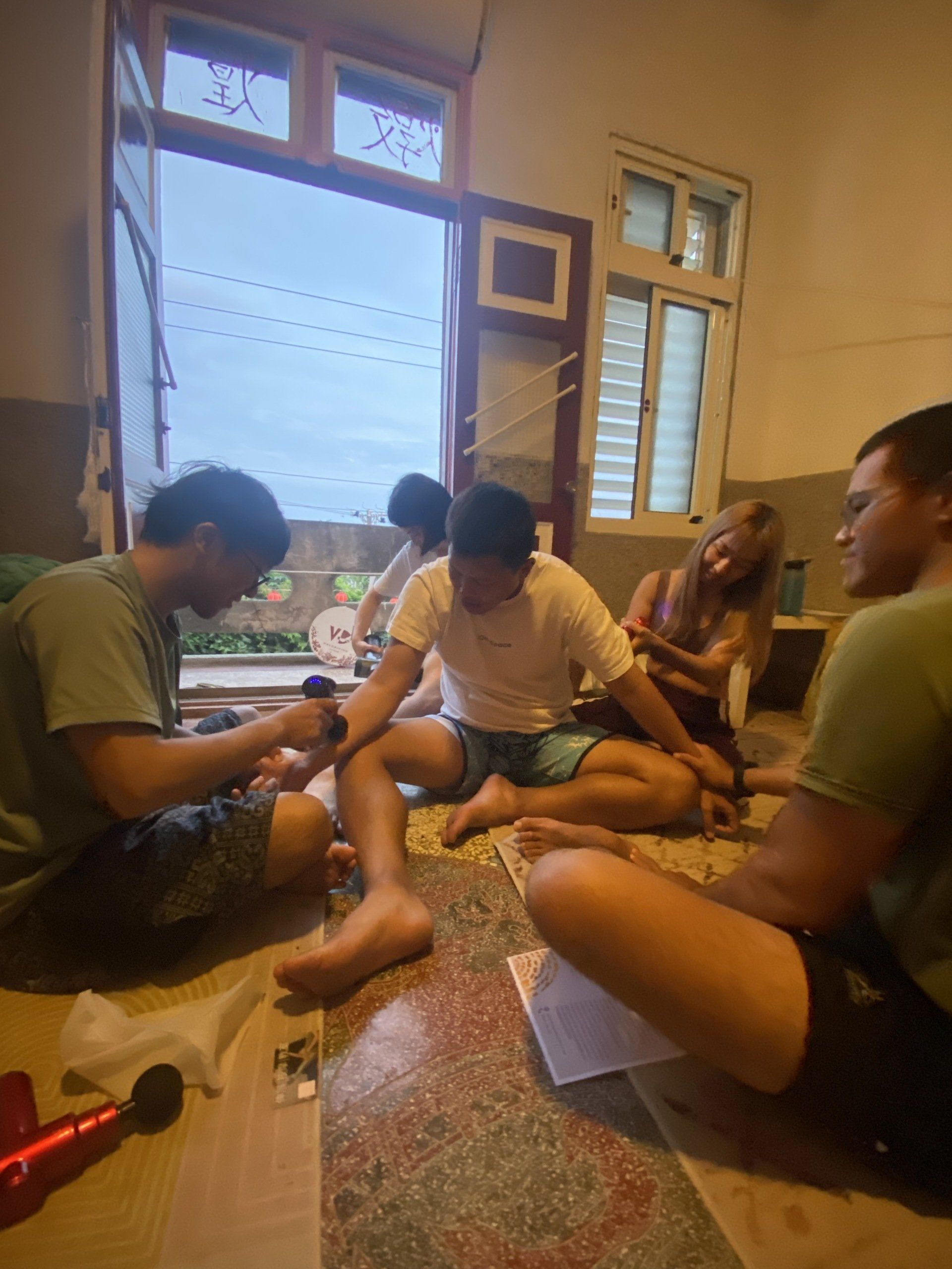 A group of people are sitting on the floor in a room.