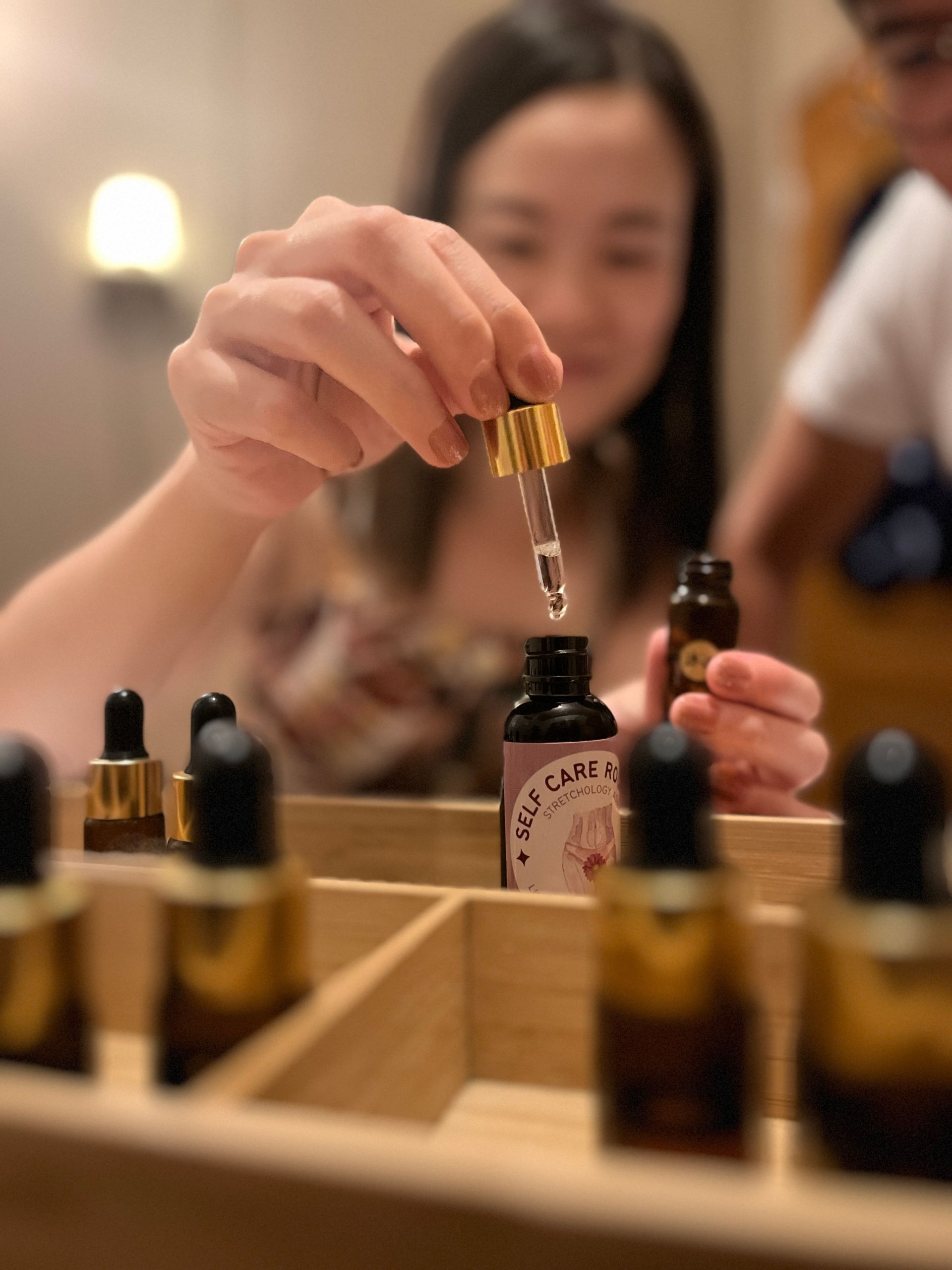 A woman is holding a bottle with a dropper in her hand