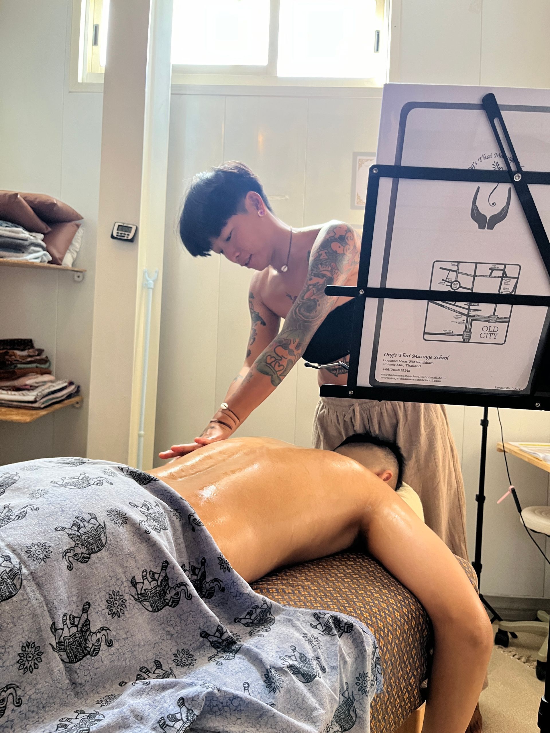 A woman is giving a man a massage in a room.