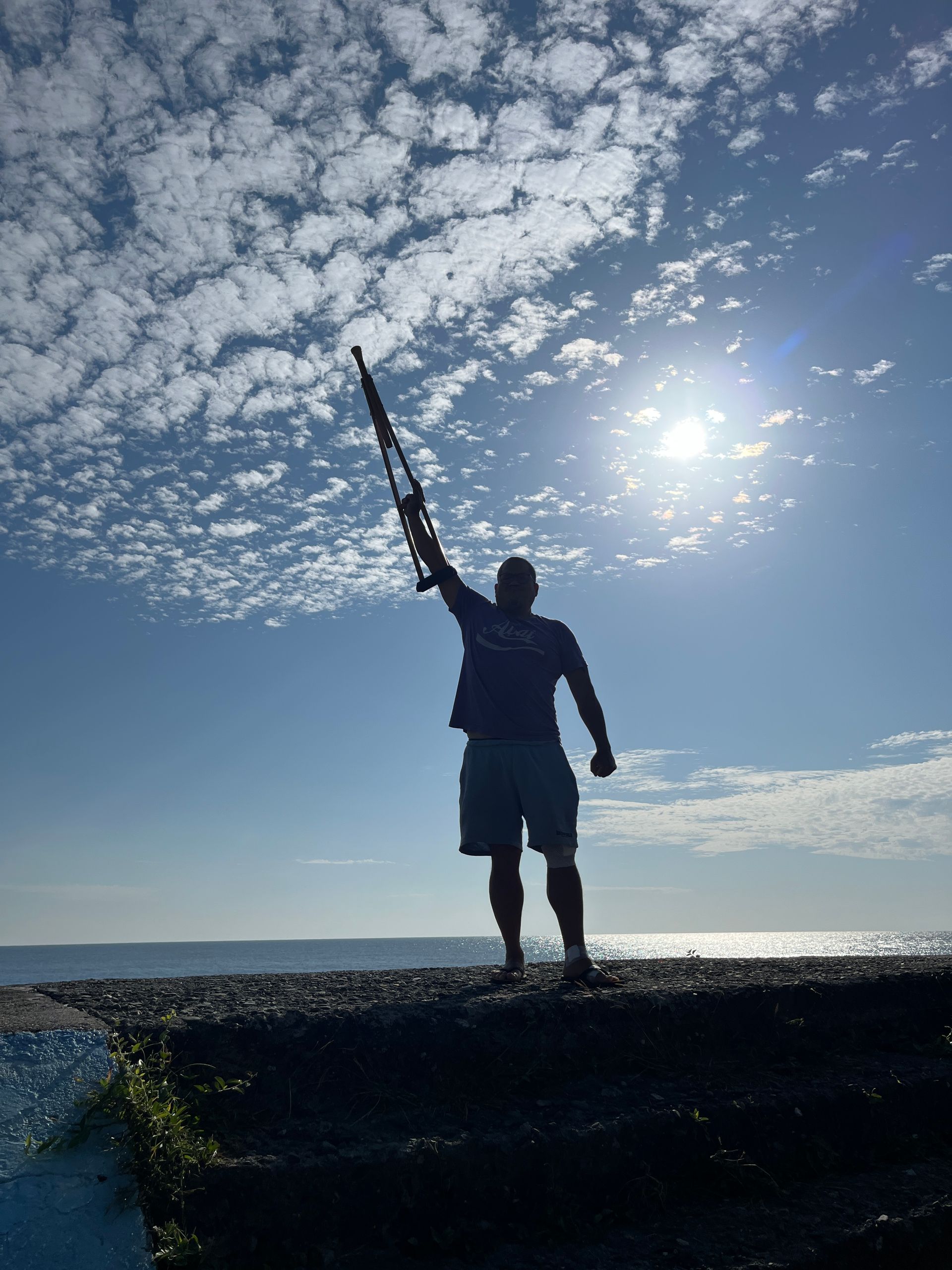 A silhouette of a man holding a fishing rod in the air