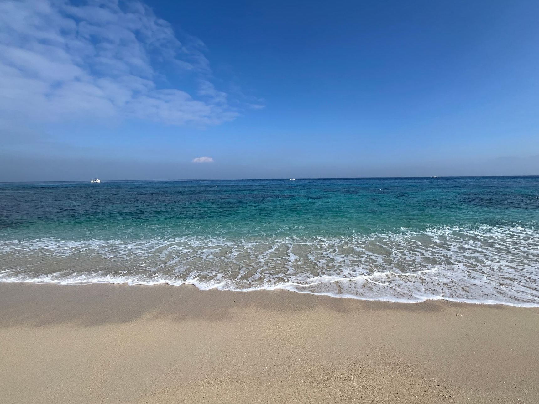 A beach with waves coming in on a sunny day