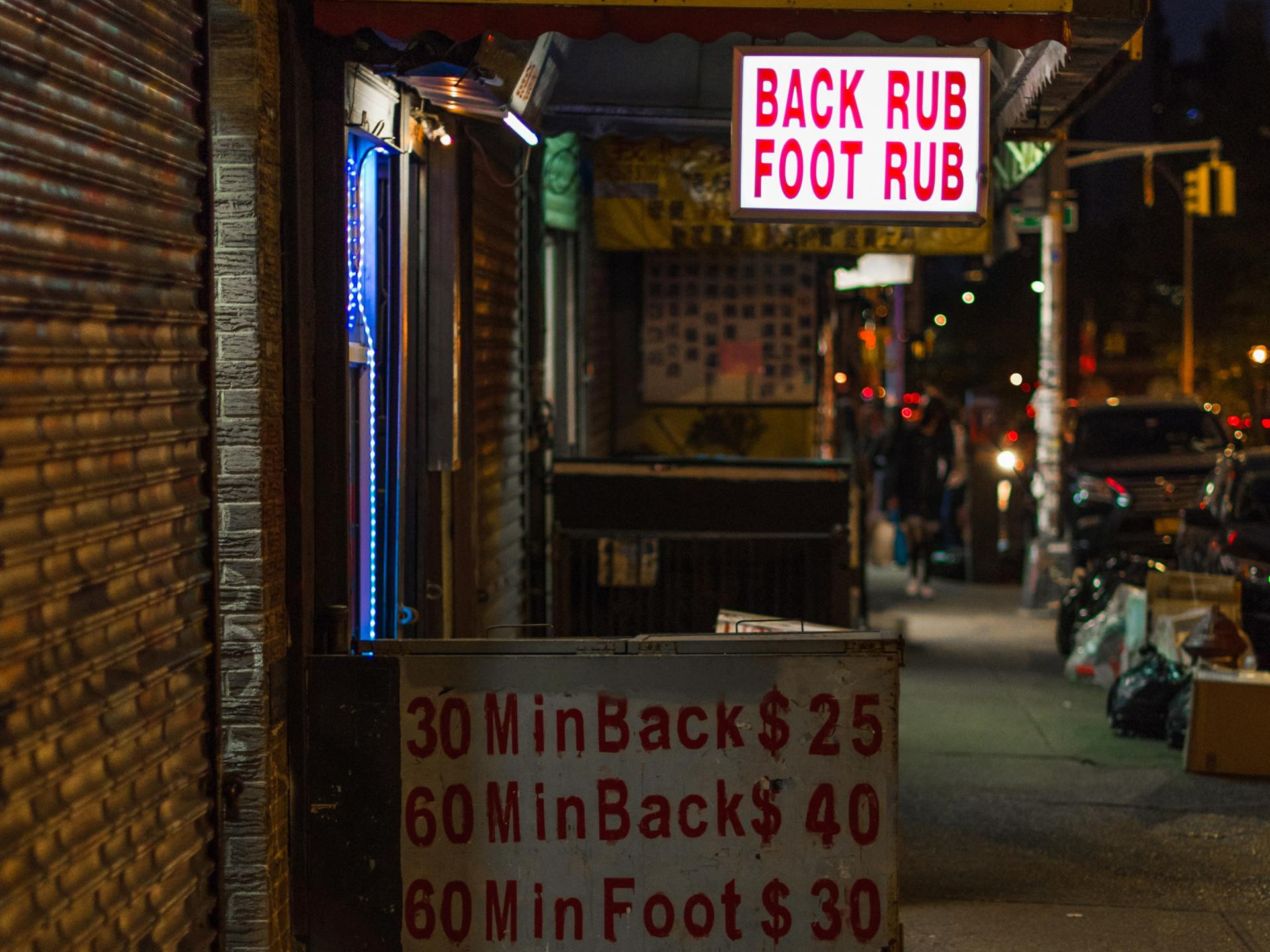A sign that says `` back rub foot rub '' is outside of a store.