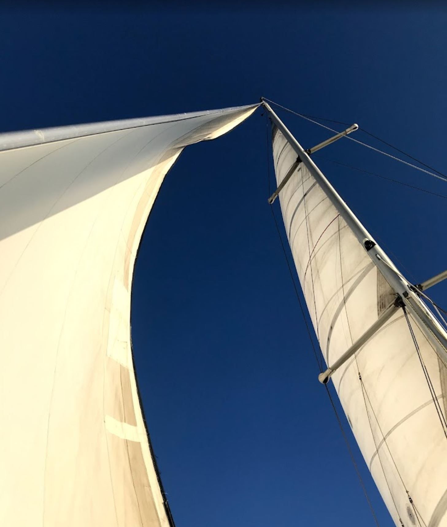 Looking up at a sailboat mast with a blue sky in the background