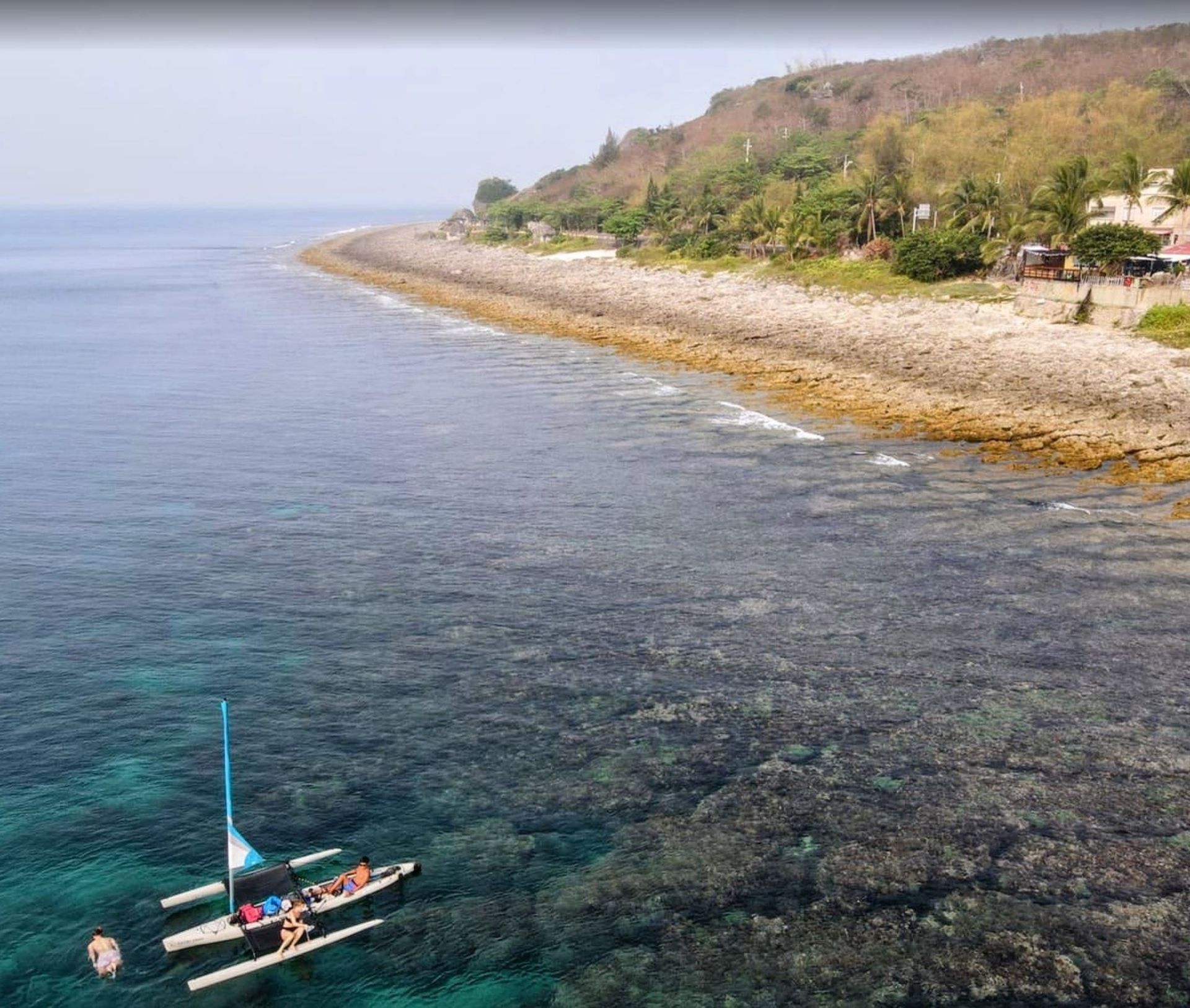 An aerial view of a boat in the ocean near a beach