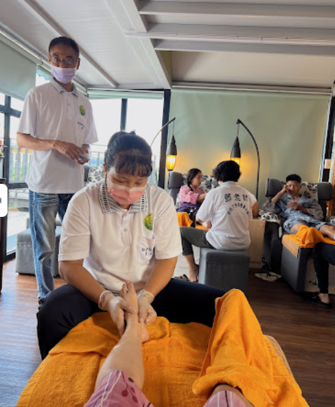 A woman wearing a mask is massaging a person 's foot