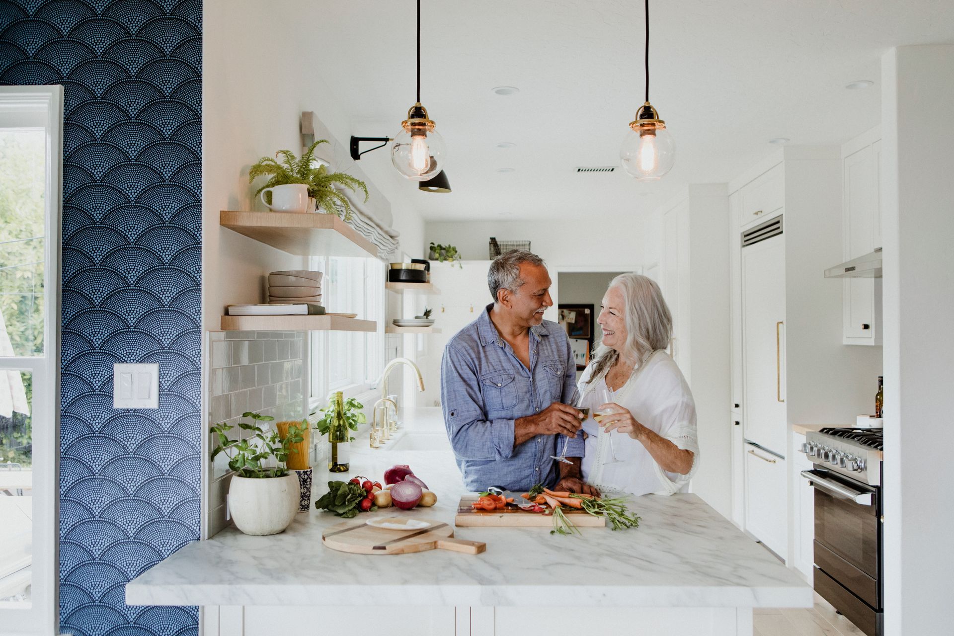 A mature couple in a newly renovated modern kitchen with a large marble island. A mature couple in a newly renovated modern kitchen with a large marble island.