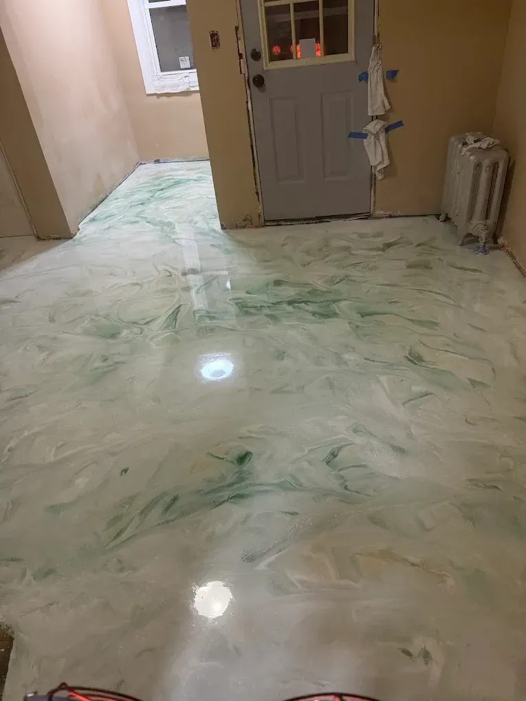 Glossy marble-floored hallway with a gray door and window, reflecting overhead lights