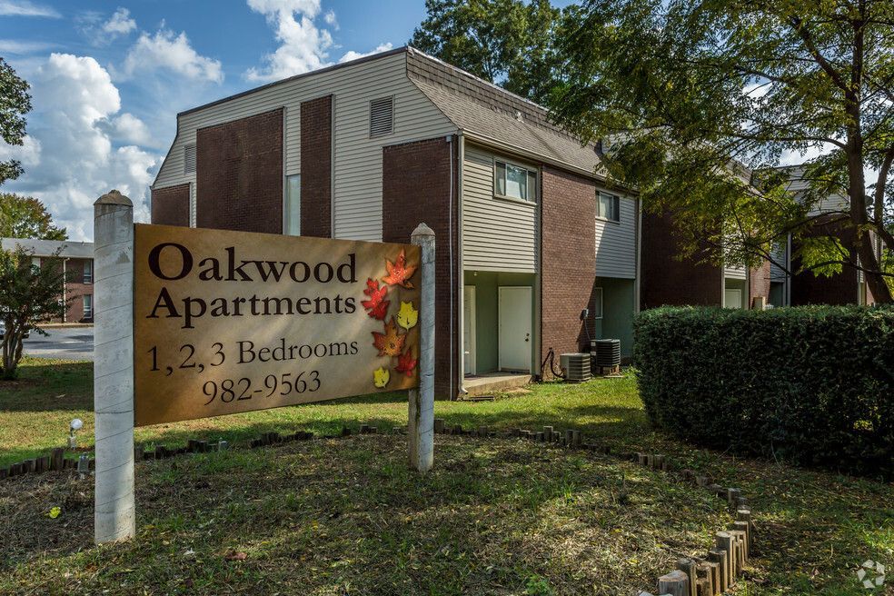 a sign that says oakwood apartments in front of a building
