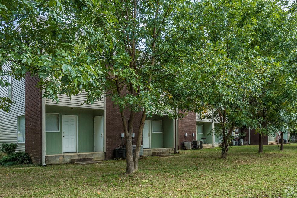 a row of apartment buildings with trees in front of them