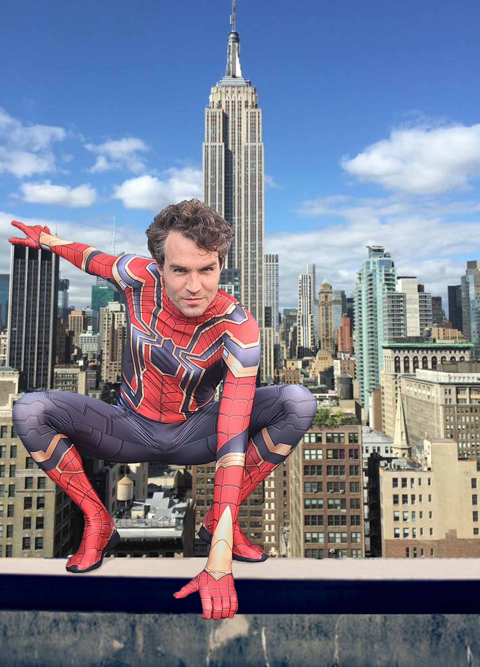 Person in Spider-Man costume crouched on a rooftop with the Empire State Building in the background.