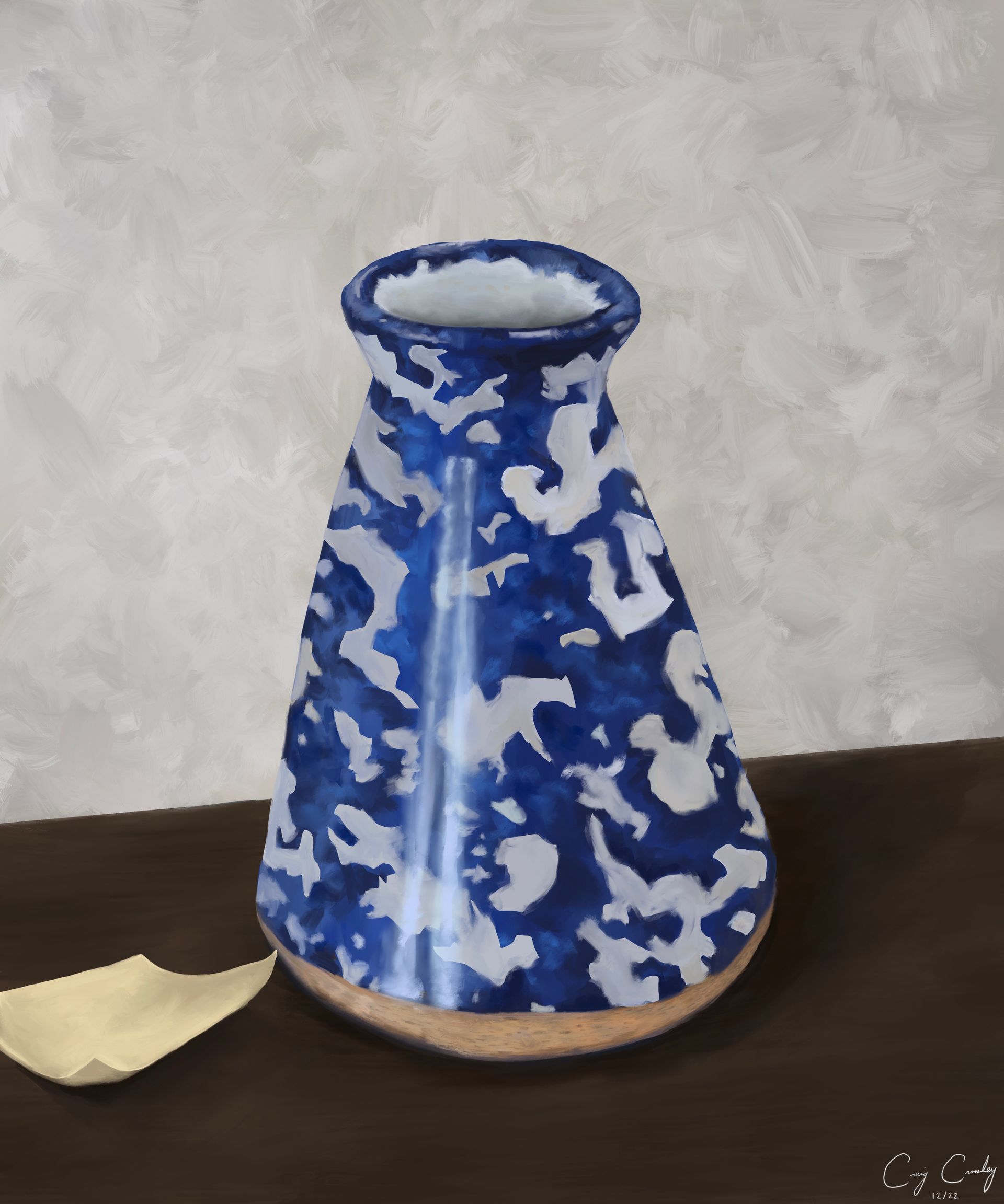 Blue and white patterned vase on a brown table with a small white paper. Background is a textured, light gray wall.