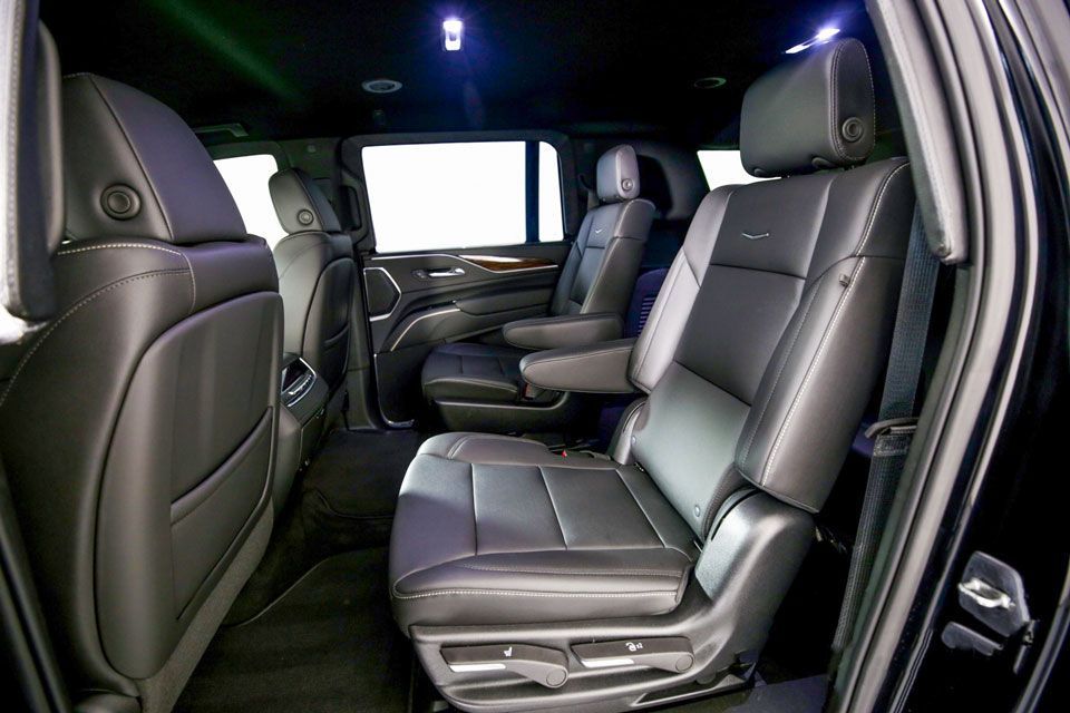 Interior view of a black SUV featuring leather bucket seats in the second and third rows.