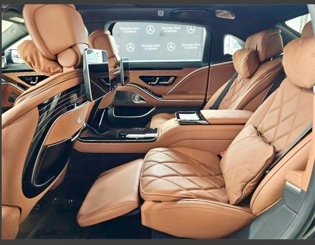 Exotic Limo Orlando Tan leather interior of a luxury car; reclined passenger seat with footrest extended, 