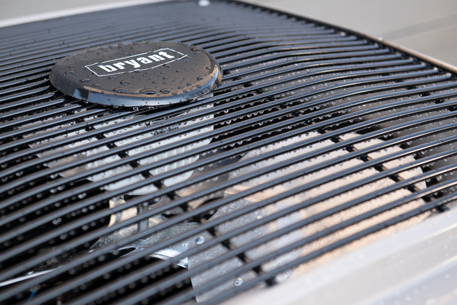 Close-up of a black Bryant air conditioner unit with curved grille slats and logo badge