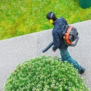 Person climbing a white wall with a rope, wearing a helmet and harness