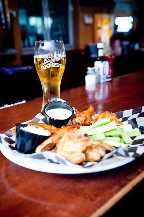 Beer and a plate of fried appetizers with dipping sauce on a bar table Beer and a plate of fried appetizers with dipping sauce on a bar table
