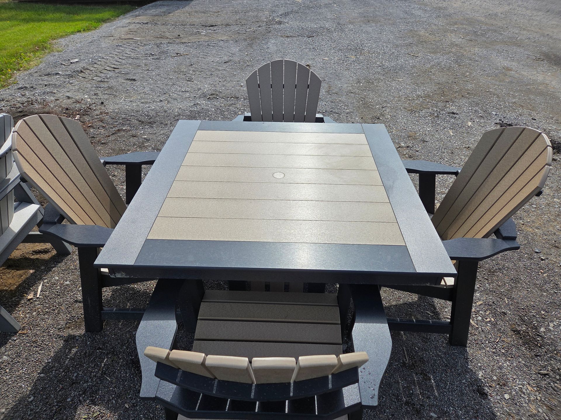 Outdoor patio table with four wooden chairs on a gravel surface