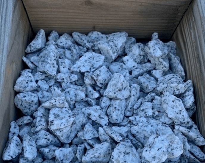 Wooden crate filled with white, speckled chunks or rocks