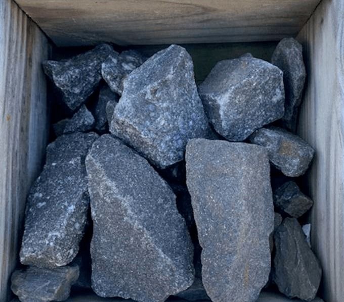 Box of gray rocks or gravel stones packed in a wooden crate