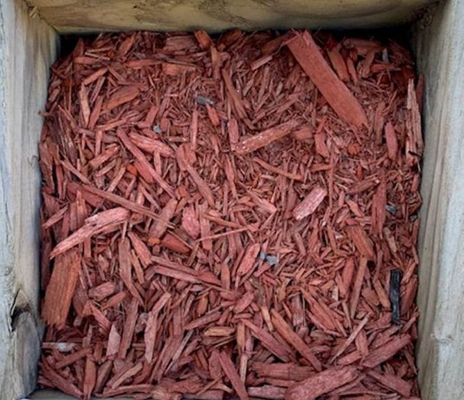 Cardboard box filled with red-brown wood chips or mulch