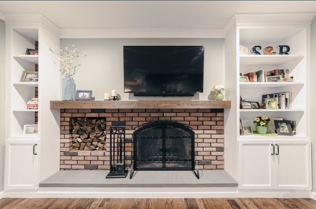 A living room with a fireplace and a flat screen tv.