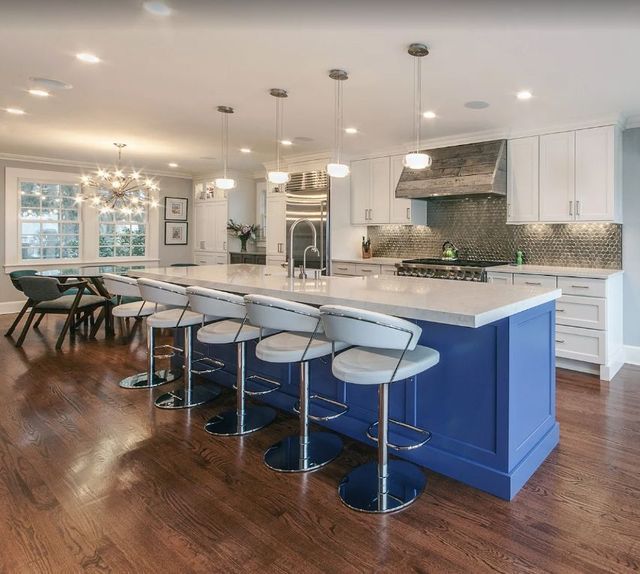 A kitchen with a blue island and white cabinets