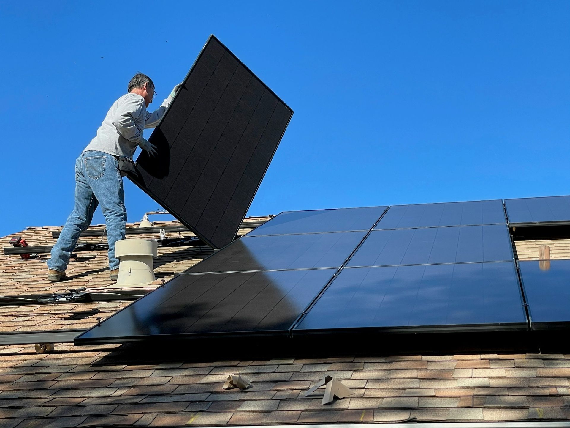 Worker installing rooftop solar panels on a home, illustrating solar panel installation cost in Florida for residential homeowners.