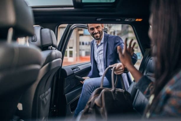 A Man is Sitting in the Back Seat of a Car Talking to a Woman  — Tweed Heads Coolangatta Taxi Service In Coolangatta, QLD