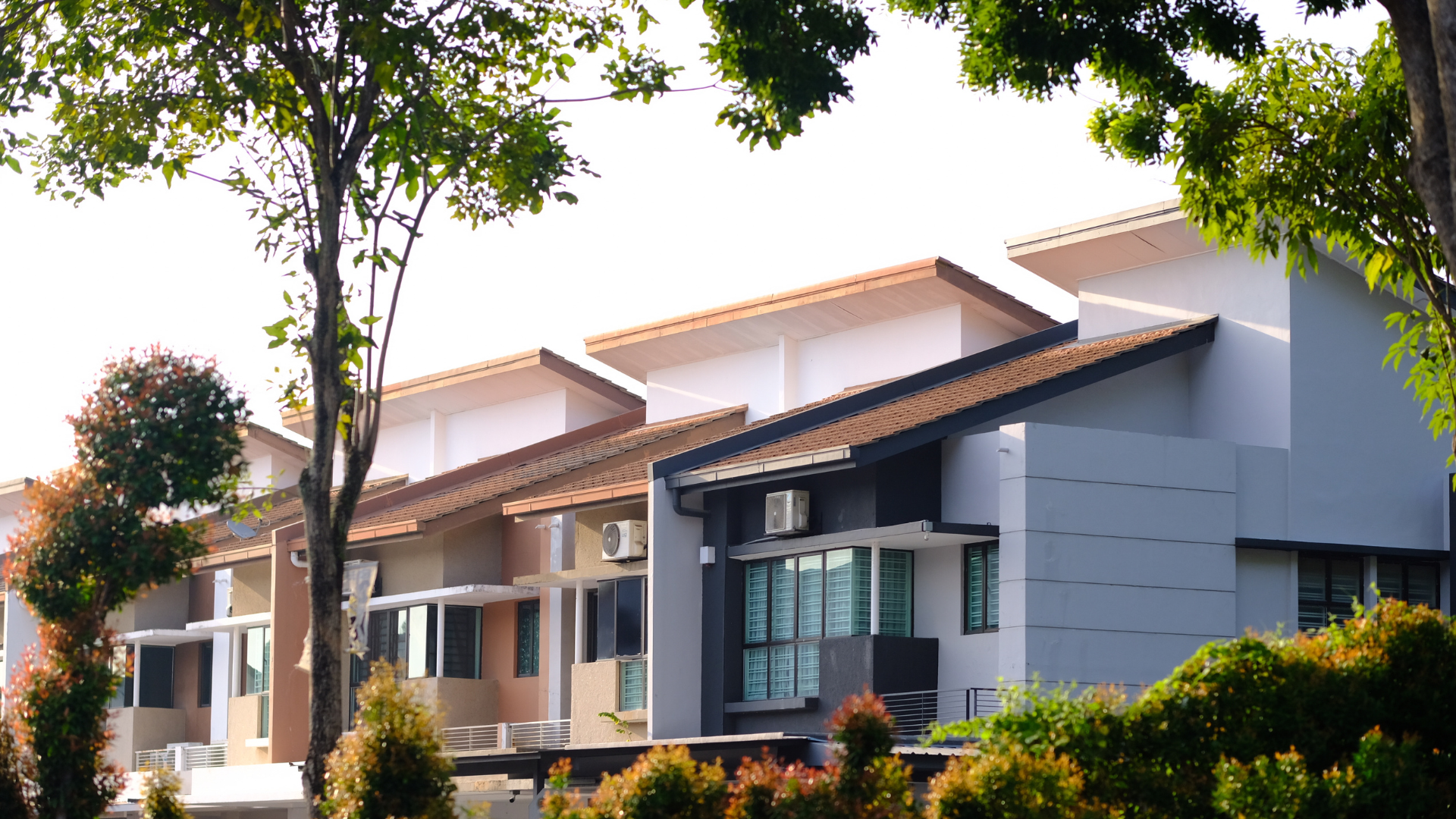 Modern apartment complex with balconies and trees in front