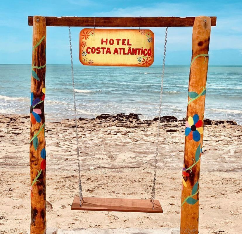 Um balanço de madeira com uma placa que diz hotel costa atlantica