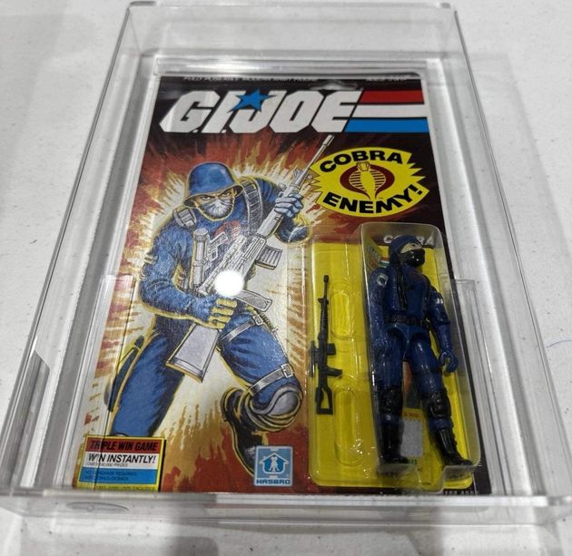 Sealed G.I. Joe action figure in plastic case, featuring a blue-clad soldier and accessories on a retro card.