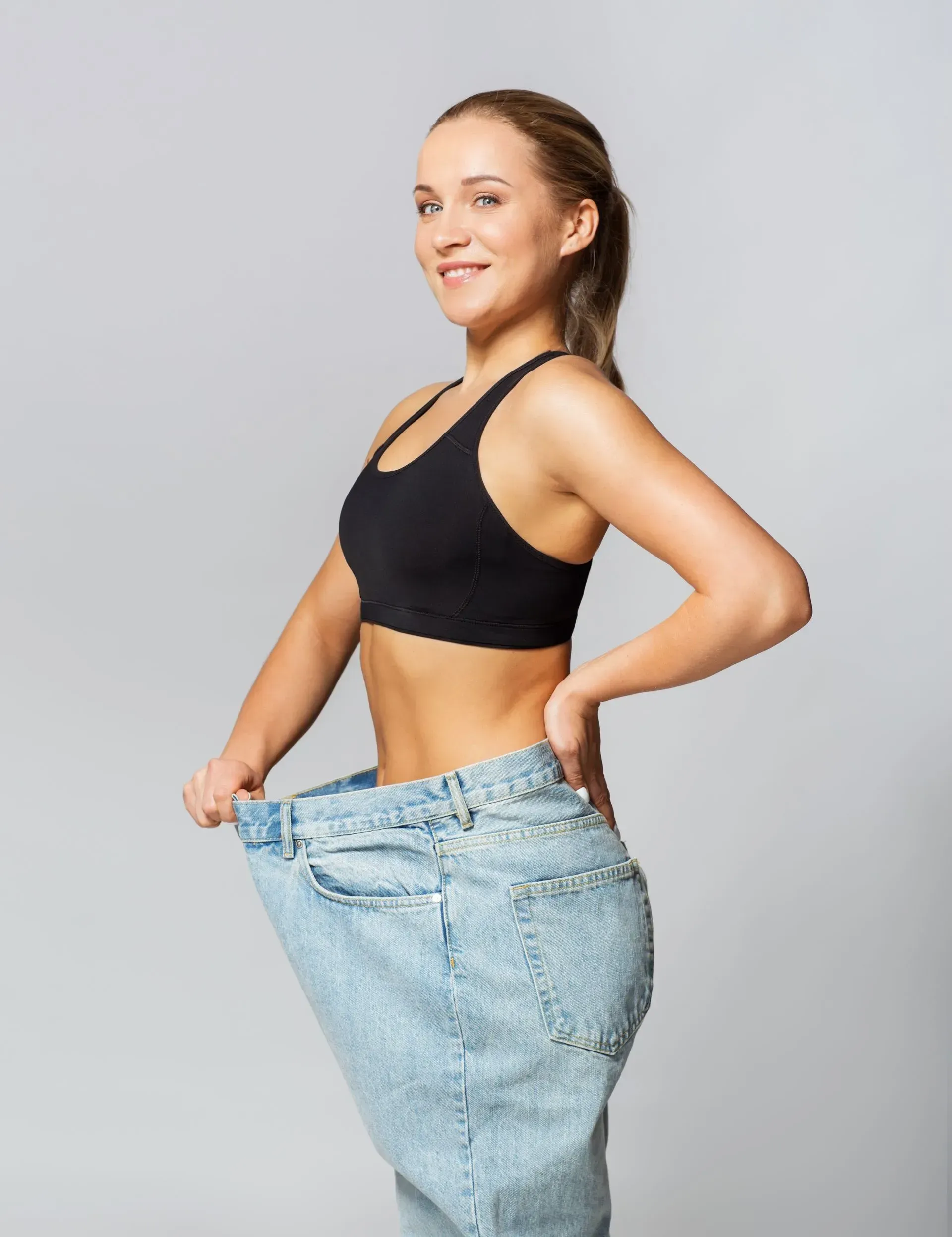 A woman is wearing a pair of very large jeans.