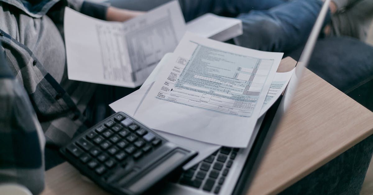 A person is sitting at a desk with a laptop and a calculator.