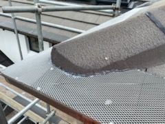Metal roof with a metal walkway, viewed from above. The walkway is next to the corrugated roofing panels.