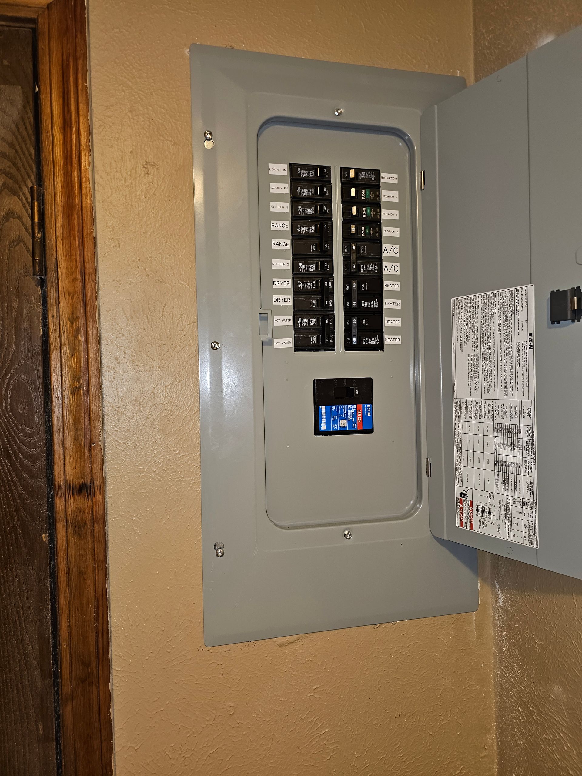 Gray electrical control panels mounted on a black frame outdoors at a construction site