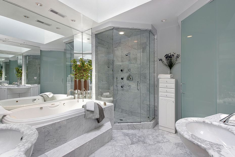 Bagno moderno piastrellato di beige con vasca da bagno, sanitari a parete e tenda alla finestra.