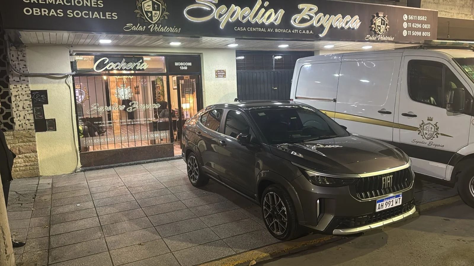 Limusina negra estacionada frente a la entrada de un edificio con fachada de piedra.