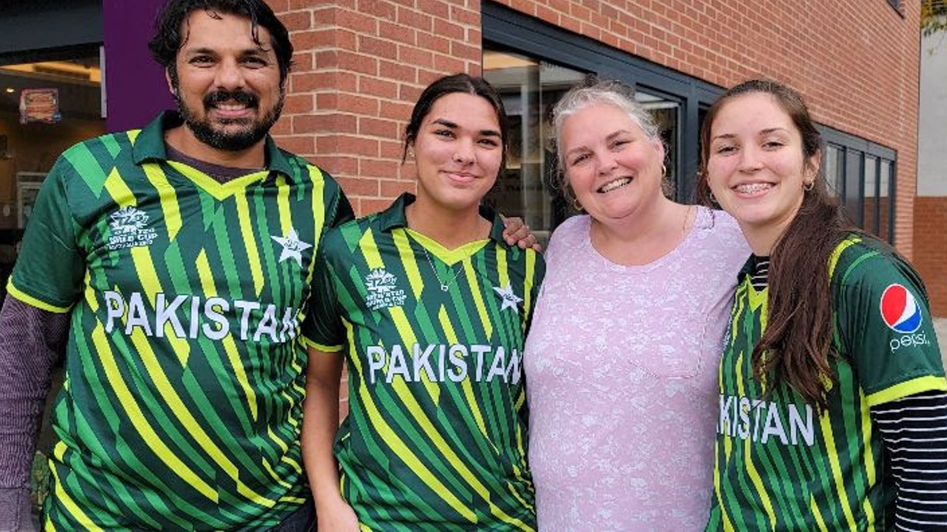 Family of four - three of whom are wearing Pakistan soccer jerseys.