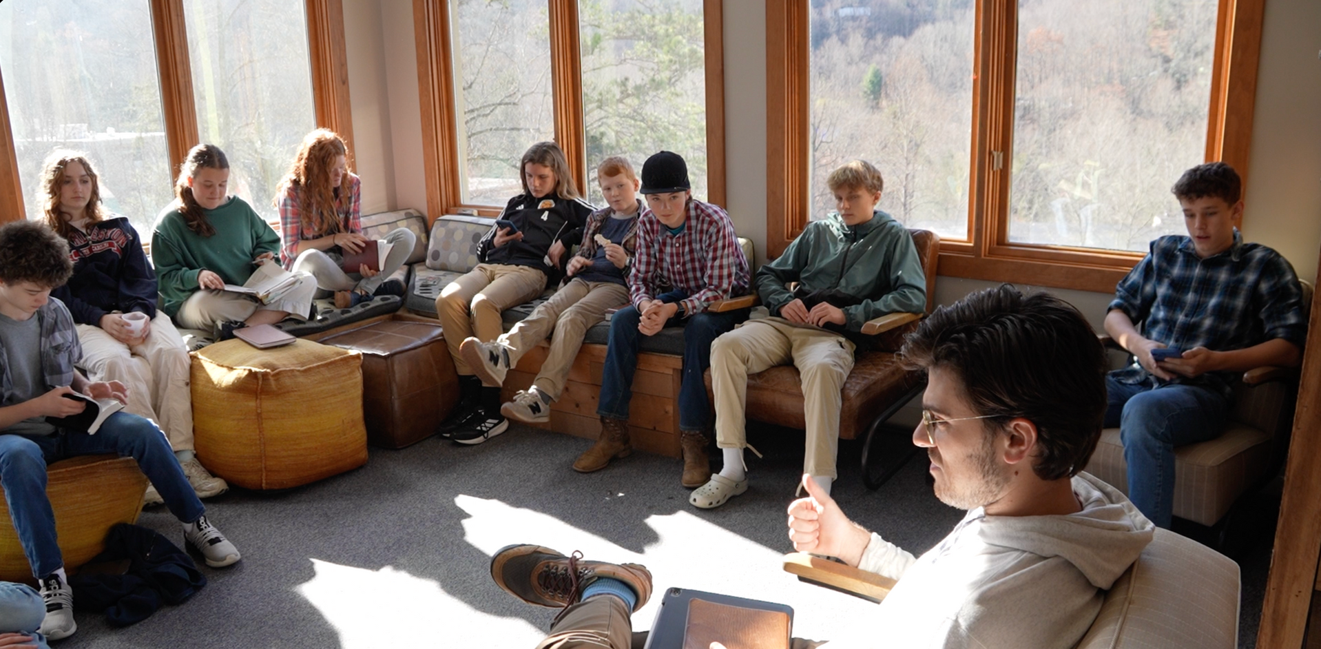 Group sitting in a bright room, listening and talking in a casual circle discussion