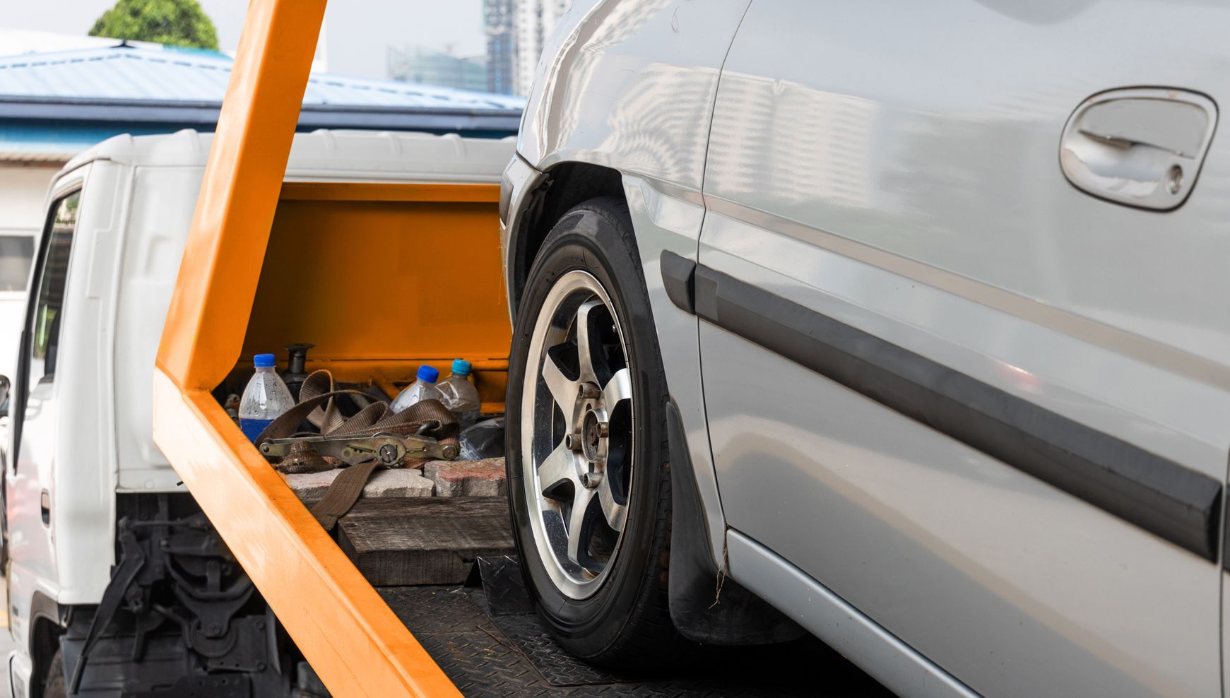 A car is being towed by a Benfleet Scrap tow truck.