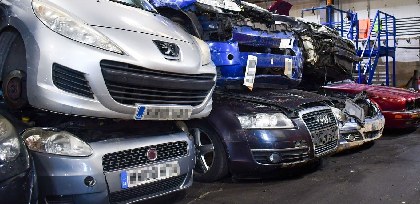 A bunch of cars are stacked on top of each other at Benfleet Scrap ready for scrapping