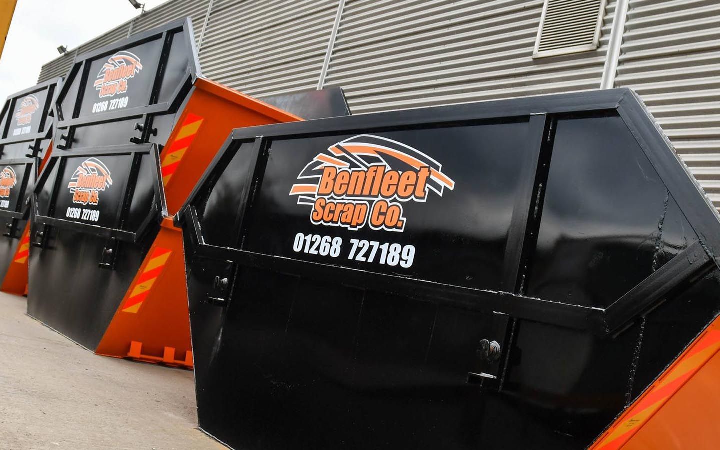 A row of Benfleet Scrap slips are lined up in front of a building.