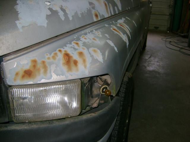 A close up of a car 's bumper with rust on it