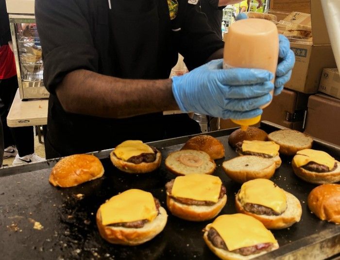 Shooters' chefs preparing burgers at an outdoor event in Nagoya.