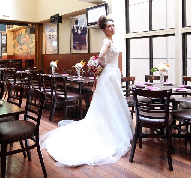 A woman in a wedding dress is standing in a restaurant in Nagoya.